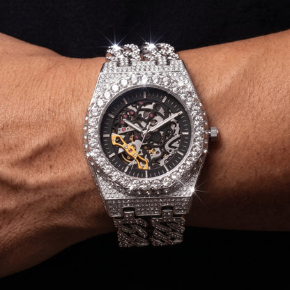 Iced out skeleton watch with visible movement and Cuban link band