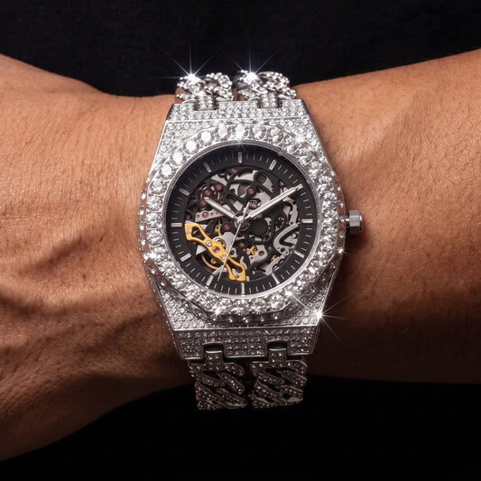 Iced out skeleton watch with visible movement and Cuban link band